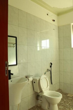 Een douche, handdoeken, zeep, toiletpapier