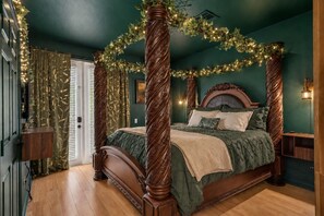 Ein Bett mit Himmelbett, ein Nachttisch aus Holz und eine Wandlampe.