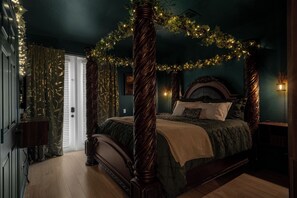 Ein Bett mit Baldachin, ein Nachttisch und eine an der Wand befestigte Lampe.