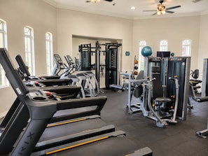 Ein Fitnessraum mit Laufbändern, Kraftgeräten und Kurzhanteln.