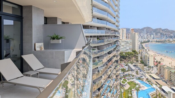Ein Hochhaus-Hotel mit Balkonen, einem Pool und Blick auf den Strand.