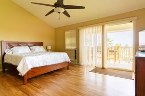 A bedroom with a bed, ceiling fan, and a view of a balcony with outdoor furniture. - Alii Cove II-4 | Monthly Rental in Kona | 30-Day Stay Alii Drive (Kailua Kona)