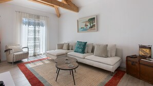 Una sala de estar con un sofá, una mesa de centro y un cuadro en la pared.