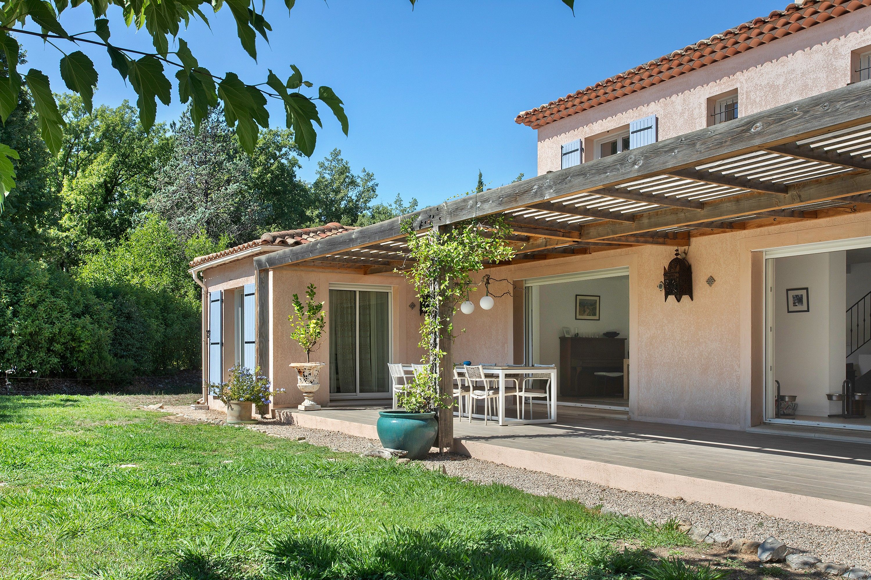 Un bâtiment à deux étages doté d’un patio, d’un coin repas et d’un espace extérieur couvert.