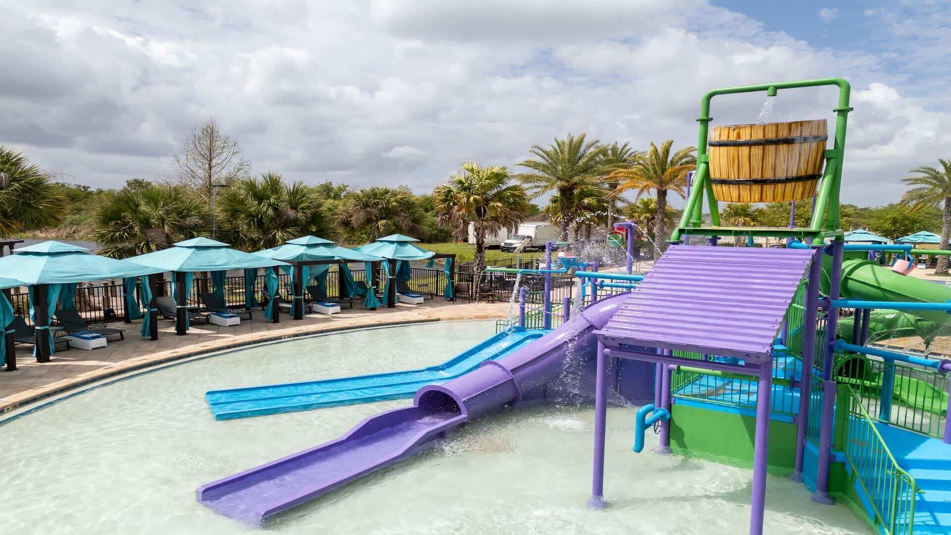 A water park with a pool, slides, and umbrellas.