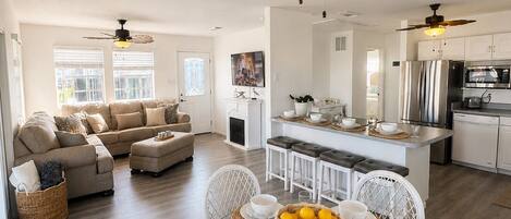 A modern kitchen with a central island, white cabinetry, and stainless steel appliances.