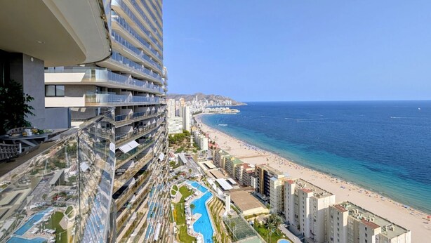 Ein Hochhaus-Hotel mit Pool, Meerblick und mehreren Balkonen.