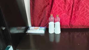 A table with a plastic container, two bottles, and a tissue box.