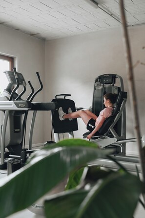A gym with exercise equipment including treadmills and a leg press machine.