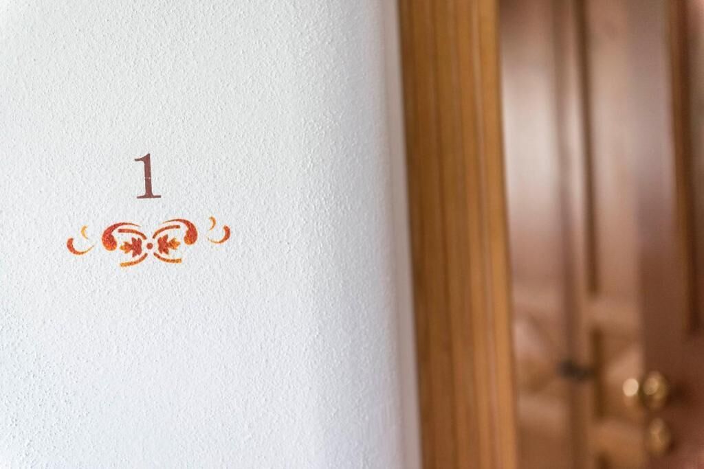 Un gros plan d’un mur blanc orné d’un chiffre « 1 » décoratif et d’un motif floral.