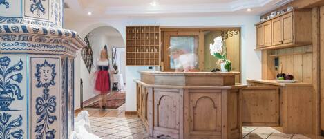 Una cocina con armarios de madera, piso de baldosas y una pared decorativa con diseños azules.