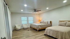 A bedroom with a bed, a chair, a ceiling fan, and a window with blinds. - Lake Texoma Haven-Luxury Getaway Near Lake Texoma w/ Hot Tub (Pottsboro)