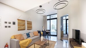 Un saló modern amb un sofà, una taula de centre, televisió i zona de menjador.