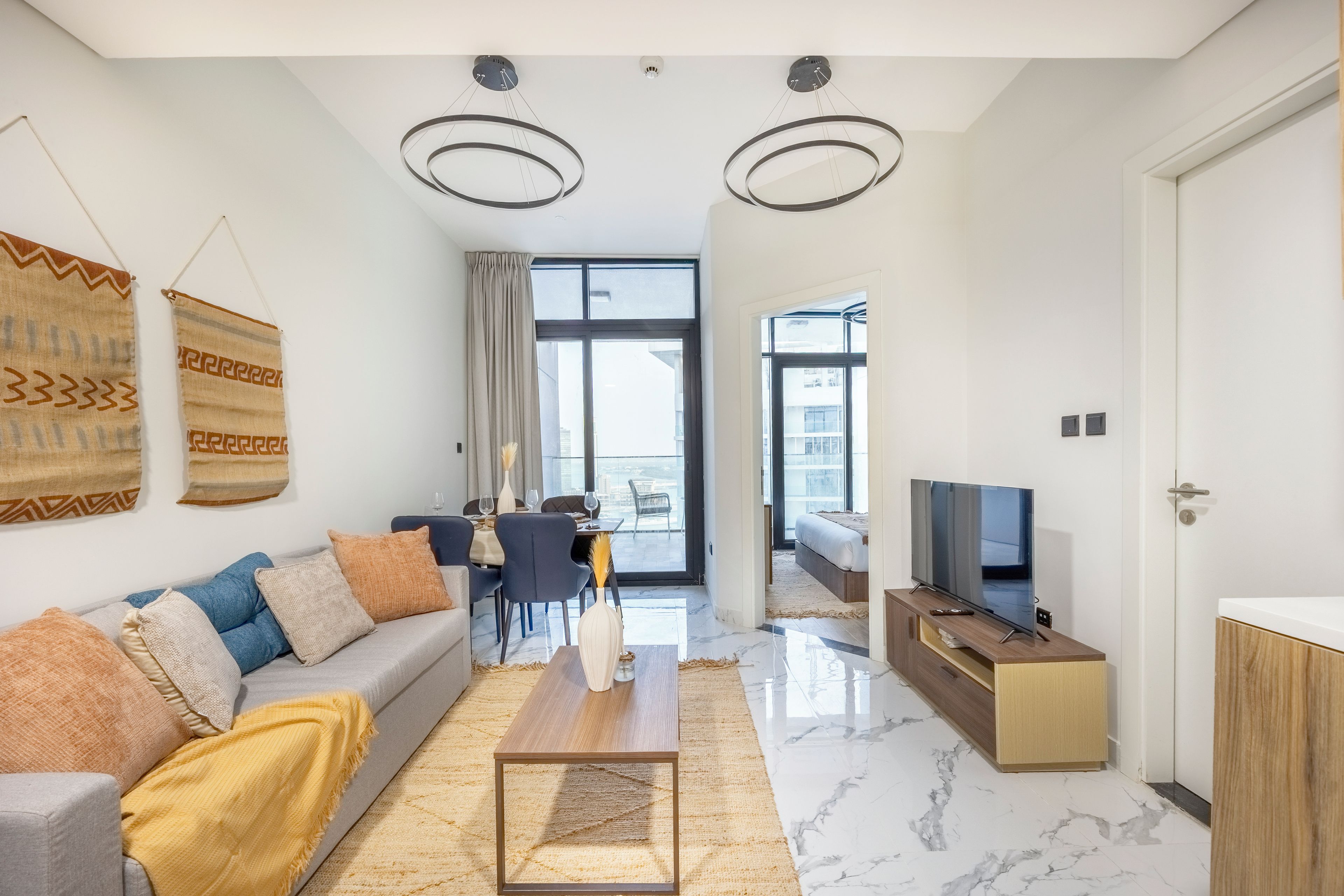 Ein modernes Wohnzimmer mit Sofa, Couchtisch, Fernseher und Essbereich.