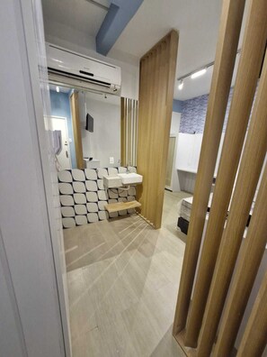 A modern bathroom with a built-in sink, a mirror, and a wooden partition. - Adorável Studio Copacabana (Rio de Janeiro)