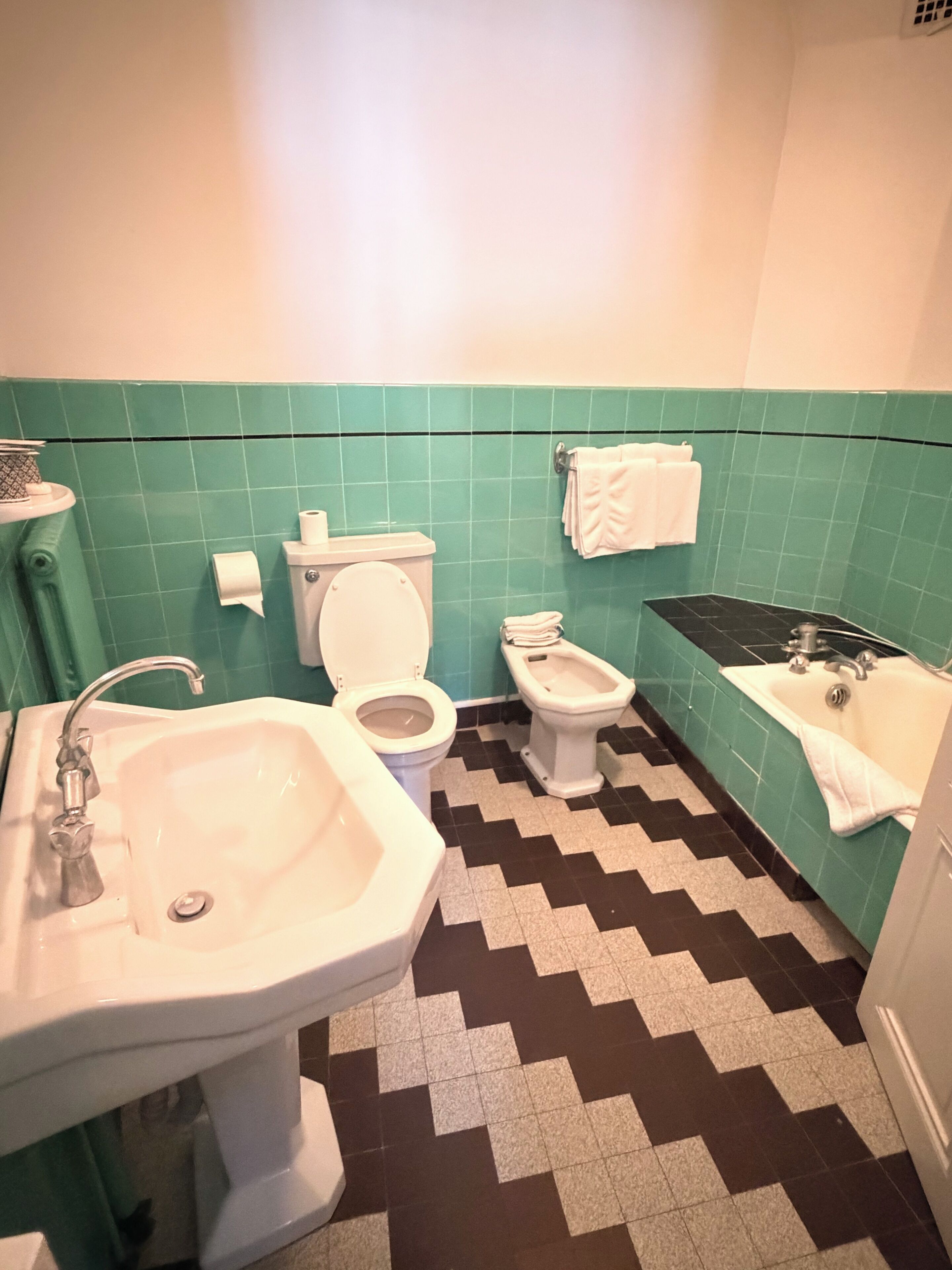 A bathroom with a sink, toilet, bidet, and bathtub.