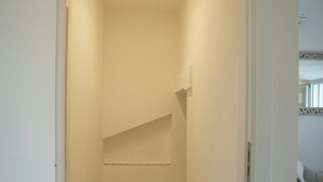 A narrow hallway with a carpeted floor, a sloped ceiling, and a door on the right.
