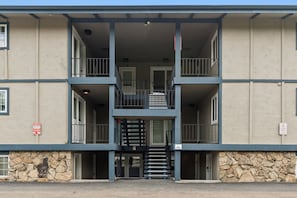 Ein mehrstöckiges Gebäude mit einer steinernen Fassade, einer zentralen Treppe und Balkonen in jeder Etage.