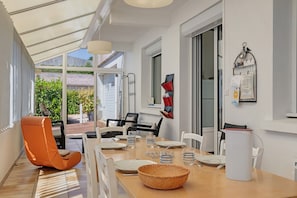A dining area with a table set for four, chairs, a wicker basket, and a white pitcher. - Holiday Home “Gîte De Chaussac” with Wi-Fi (Saint-Laurent-sur-Sèvre)