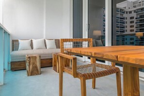 Ein modernes Wohnzimmer mit einem Holzesstisch, einer Couch mit Kissen und einem kleinen Holzschemel.