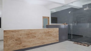 Una zona d'entrada moderna amb un taulell de fusta, una separació de vidre i una porta que dona a una altra estança.