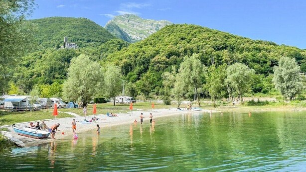 A lakeside setting with boats, a beach, and a mountain backdrop. - Casa Marina - Minucciano (Minucciano)