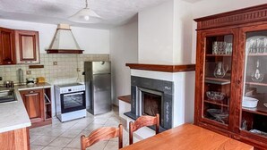 A kitchen with a wooden table, chairs, and a cabinet with glass doors. - Casa Marina - Minucciano (Minucciano)