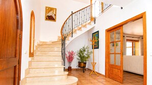 A staircase with a wooden handrail, a potted plant, and a door leading to another room. - 286 Palmitos 1 by Mallorca Charme (Can Picafort)