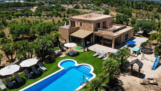 A large building with a swimming pool, outdoor seating, and a view of the surrounding landscape. - 286 Palmitos 1 by Mallorca Charme (Can Picafort)