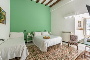 Une chambre avec deux lits, un tapis à motifs, une chaise et un radiateur.