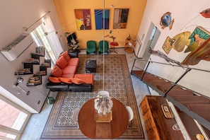 A spacious living area with a sofa, chairs, a coffee table, and artwork on the walls. - Marzapane apartment near Porta Carini (PALERMO)