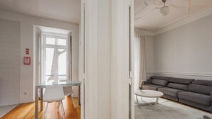 A modern living room with a glass dining table, a gray sofa, and a white coffee table. - Merlot Apartment, Marquês de Pombal, Lisbon (Lisboa)