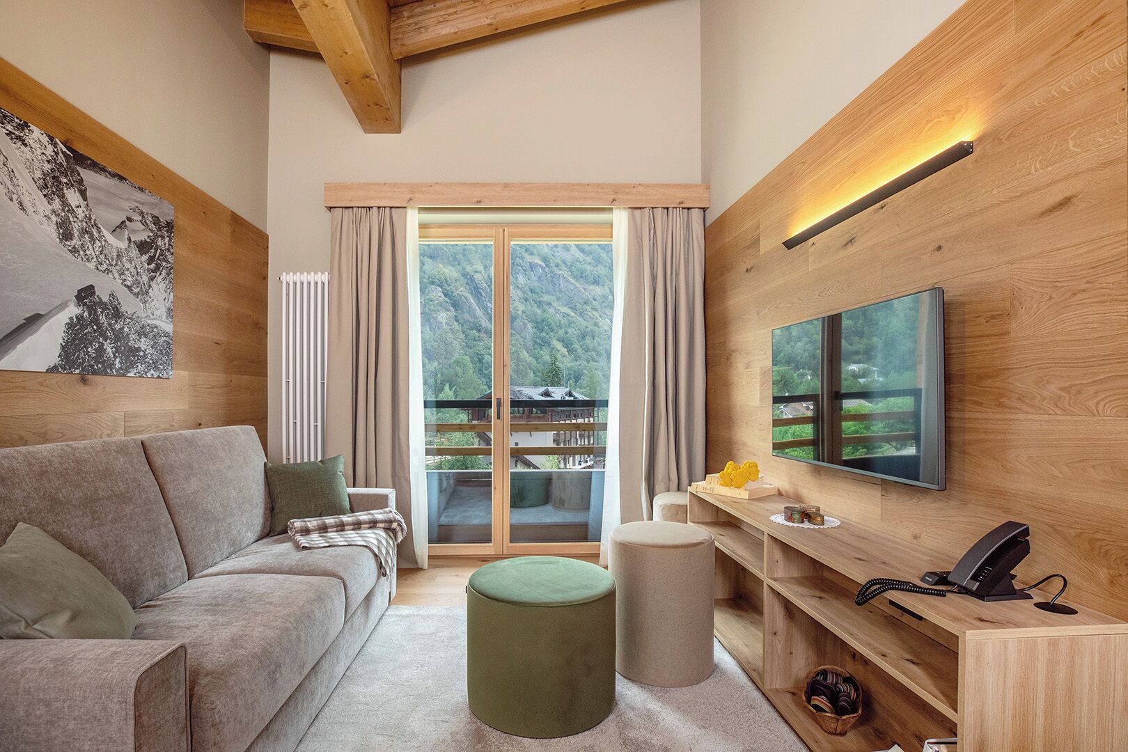 Un salon moderne avec un canapé, un pouf et un téléviseur à écran plat fixé à un mur en bois.