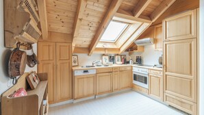 A kitchen with wooden cabinets, a dishwasher, an oven, and a skylight. - Ski-in · Luxury Alpine Apartment · Celerina (Celerina/Schlarigna)