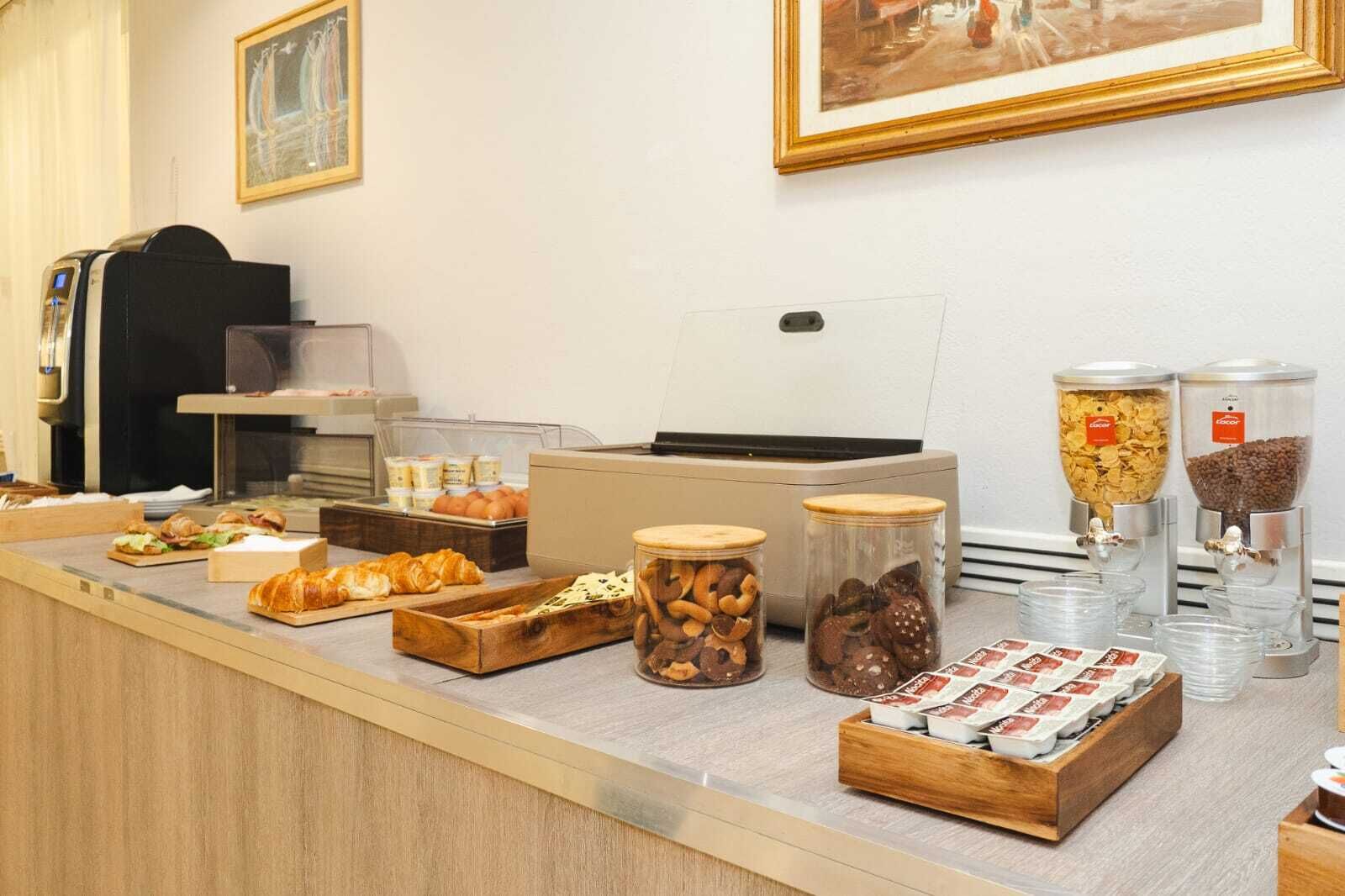 A breakfast buffet with various food items, including pastries, nuts, and cereals.