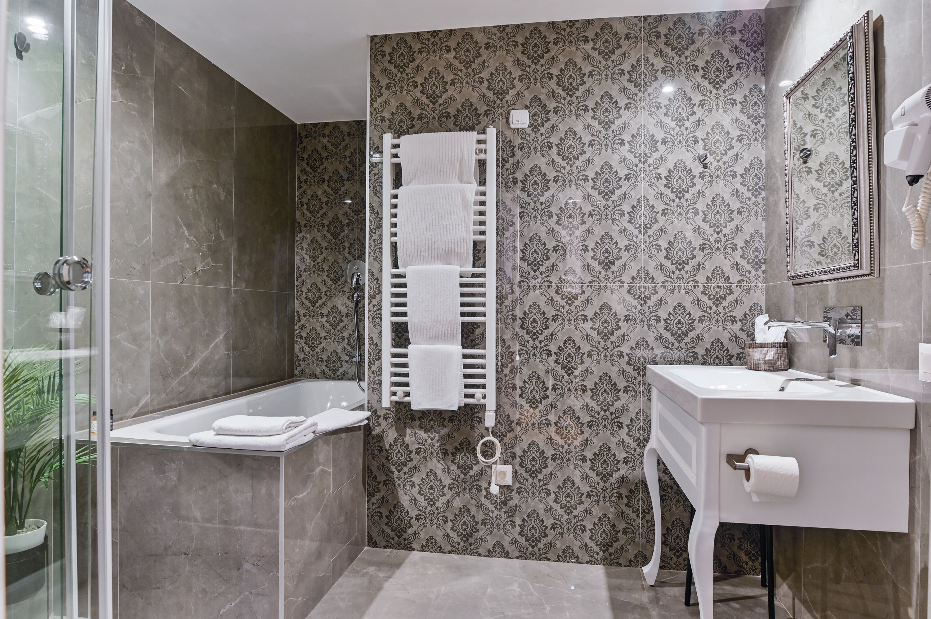 A bathroom with a shower, a bathtub, a towel rack, a sink, and a mirror.
