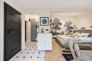 A modern bedroom with a bed, bedside tables, a wardrobe, and a decorative wall piece. - Warsaw Muranów Studio — Old Town & Metro (Warszawa)