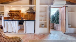 Una cocina con horno integrado, un lavamanos y un refrigerador pequeño.