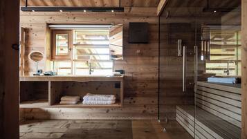 Un interno moderno in legno con lavabo integrato, uno specchio e un porta asciugamani.