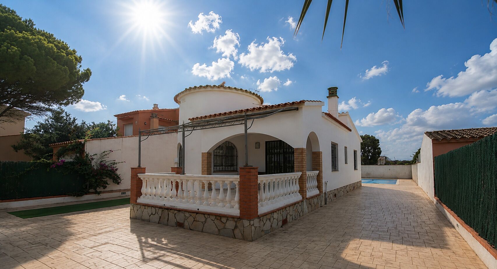 Uma villa com um alpendre coberto de azulejos, uma piscina e céu claro.