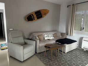 Uma sala de estar com sofá, poltrona e mesa de madeira.
