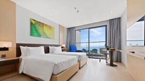 Ein Hotelzimmer mit zwei Betten, einem Schreibtisch, einem Stuhl und einem großen Fenster.