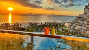 Ein Sonnenuntergangsblick vom Balkon mit Blick auf Pool und Resort.