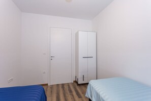 A room with two beds, a wardrobe, and a door. - Premium beachfront apartment (Banjole)