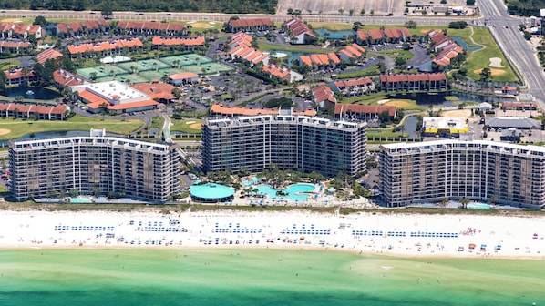 A coastal resort with multiple high-rise buildings, a central pool area, and a beach with umbrellas. - 3BR Edgewater Condo | Pools, Golf, Tennis & Private Beach Access! (Panama City Beach)
