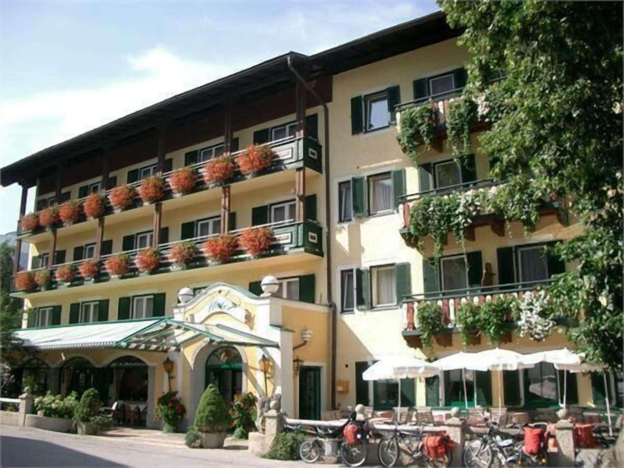 A multi-story hotel with balconies, outdoor seating, and bicycles.