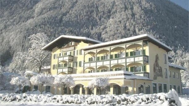 Un hôtel à plusieurs étages, doté de balcons, situé dans un cadre montagneux.