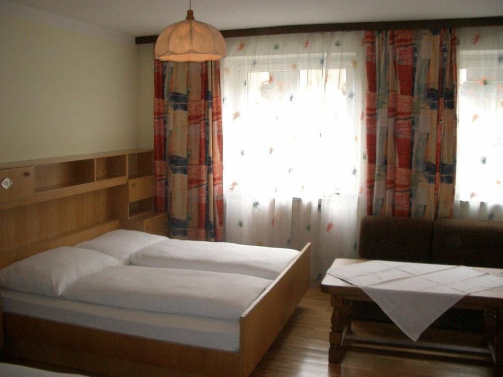 A room with a bed, a table, and a chair.