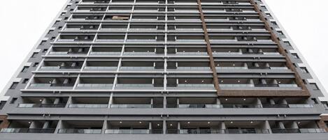 Un edificio de gran altura con múltiples balcones y un diseño arquitectónico moderno.