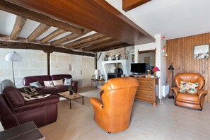 A cozy living room with a leather sofa, a leather armchair, and a wooden coffee table.